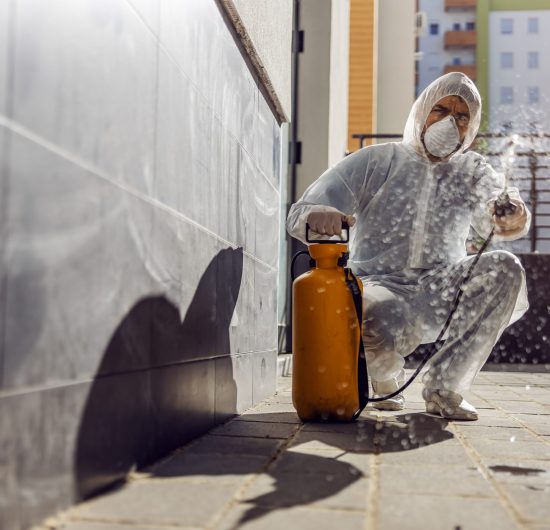 Cleaning and Disinfection outside around buildings, the coronavirus epidemic. Professional teams for disinfection efforts. Infection prevention and control of epidemic. Protective suit and mask. Professional specialist full protective cleaning outside.